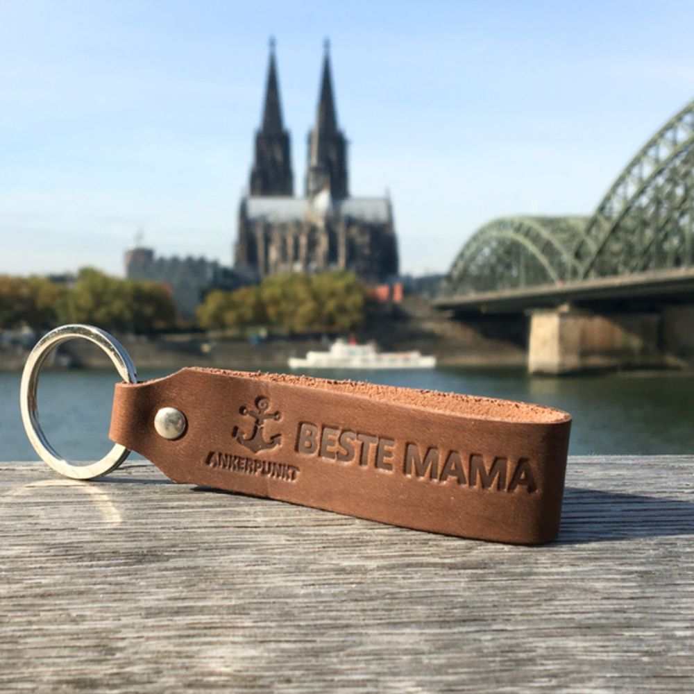 Dunkelbrauner Leder-Schlüsselanhänger "Beste Mama" vor Kölner Dom.