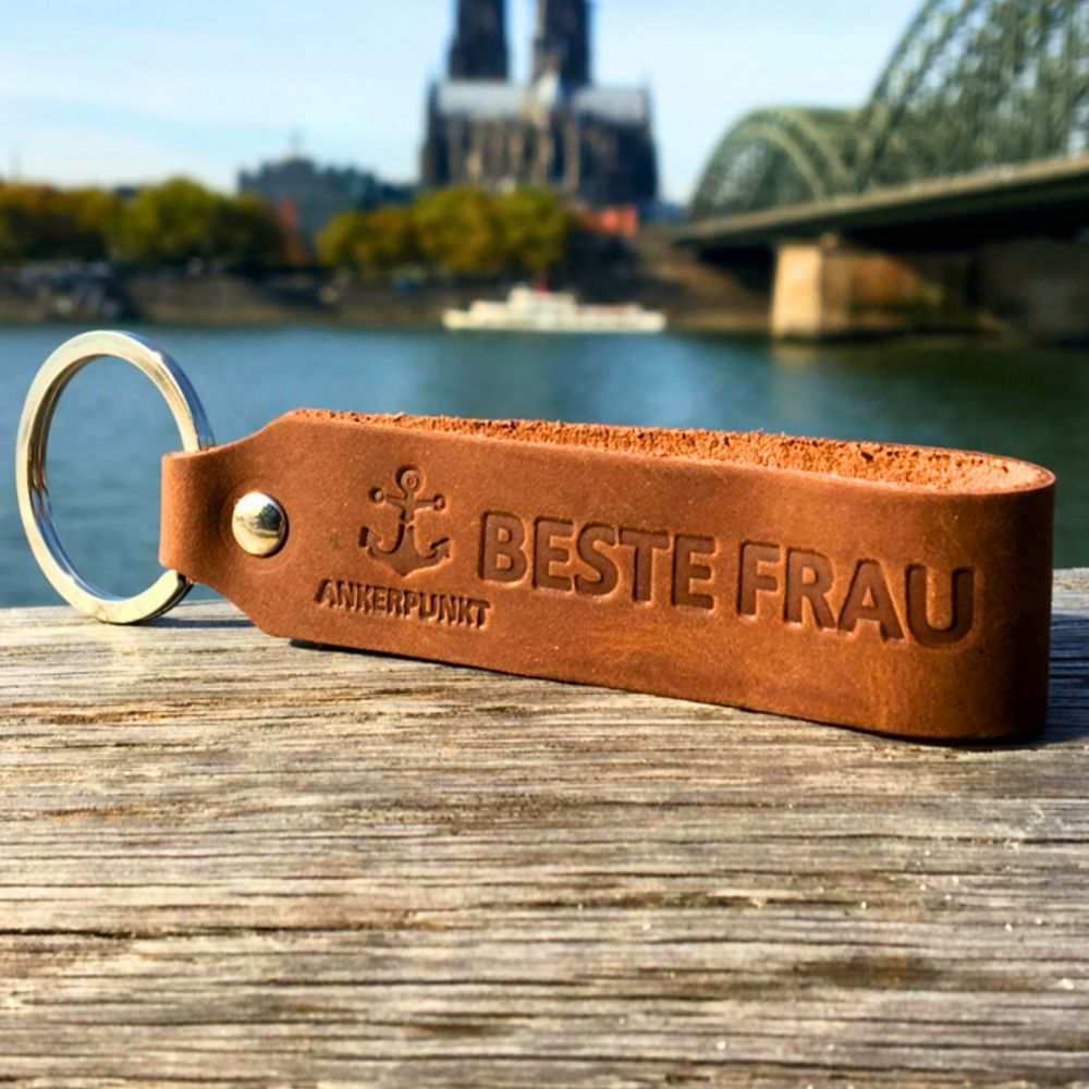 Dark brown leather keychain for "Beste Frau" with river and bridge background. Made from durable German full-grain leather by ANKERPUNKT.
