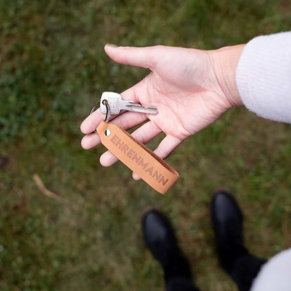 Leder Schlüsselanhänger Set Ehrenmann hellbraun in Hand gehalten.