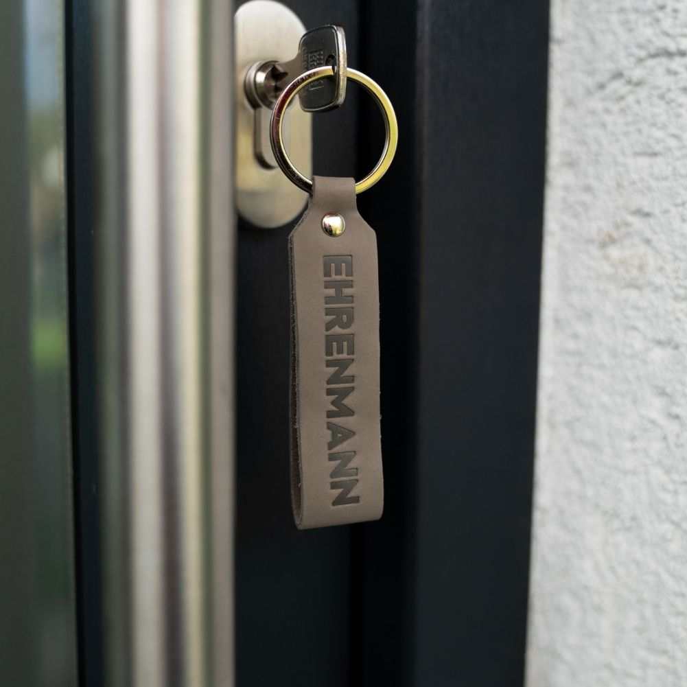 Ehrenmann & Ehrenfrau grey leather keychain set in door lock, handmade in Germany.
