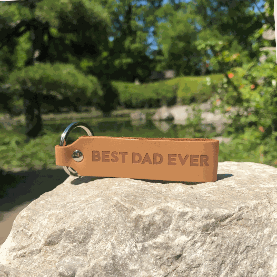 Leather keychain with "Best Dad Ever" engraving on a rock.
