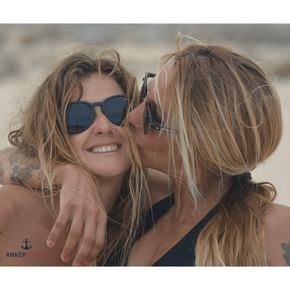 Stylish women enjoying beach with ANKERPUNKT leather keychain.