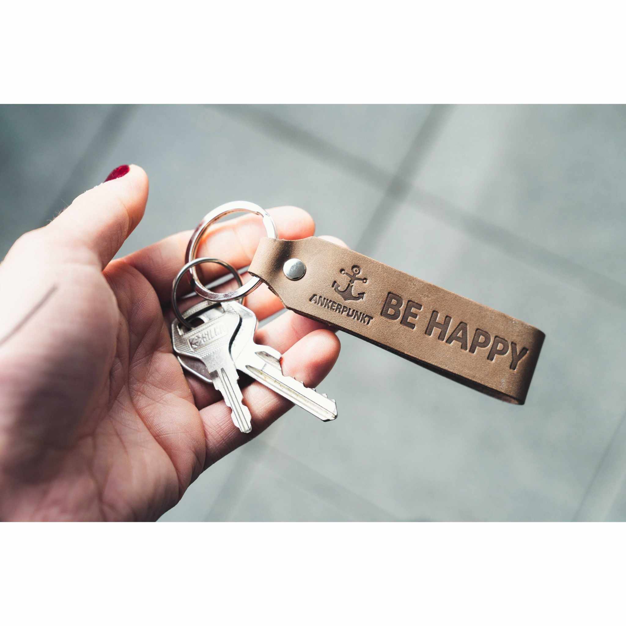 Schlüsselanhänger Leder mit Gravur "Be Happy" in dunkelbraun von ANKERPUNKT.