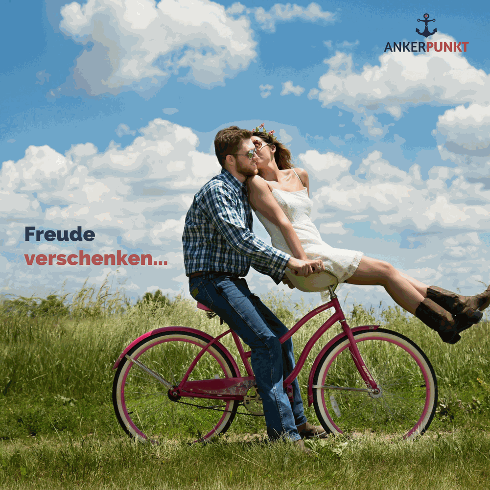 Loving couple sharing a joyful moment on a bicycle in a field under a blue sky, featuring ANKERPUNKT branding.