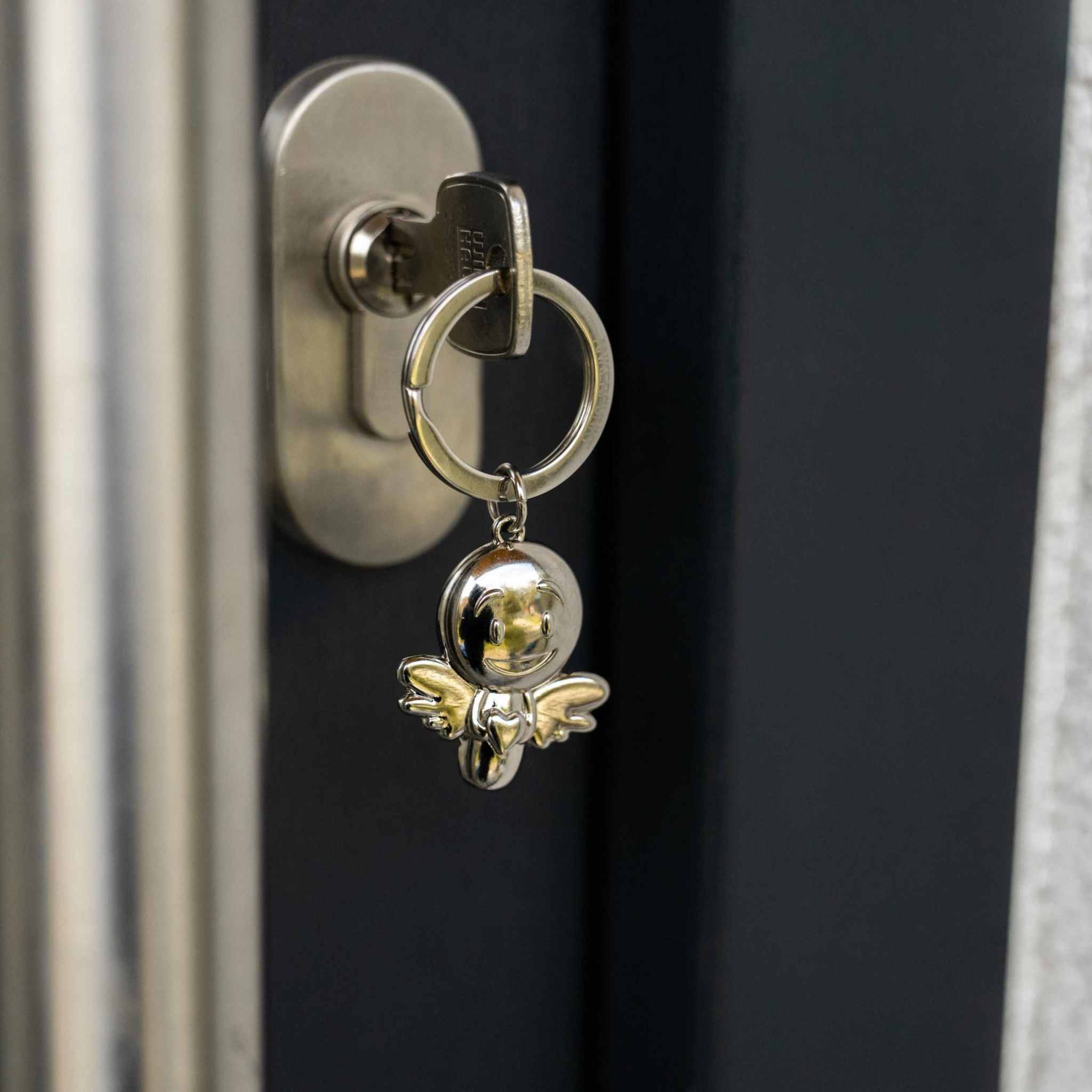Silver shiny angel keychain in door lock, Schutzengel Schlüsselanhänger.