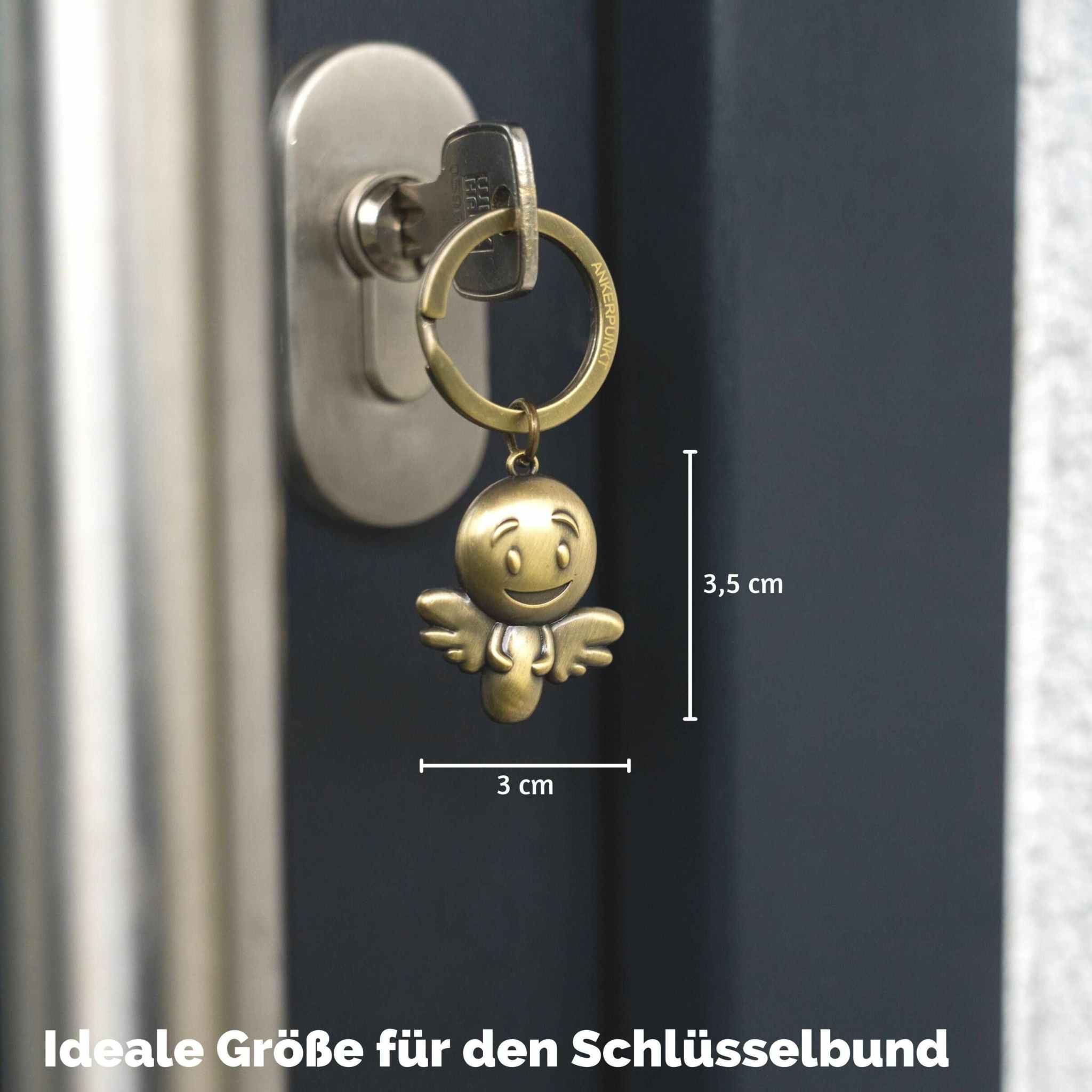 Gold vintage Schutzengel Schlüsselanhänger with smiley face, attached to key in door lock.
