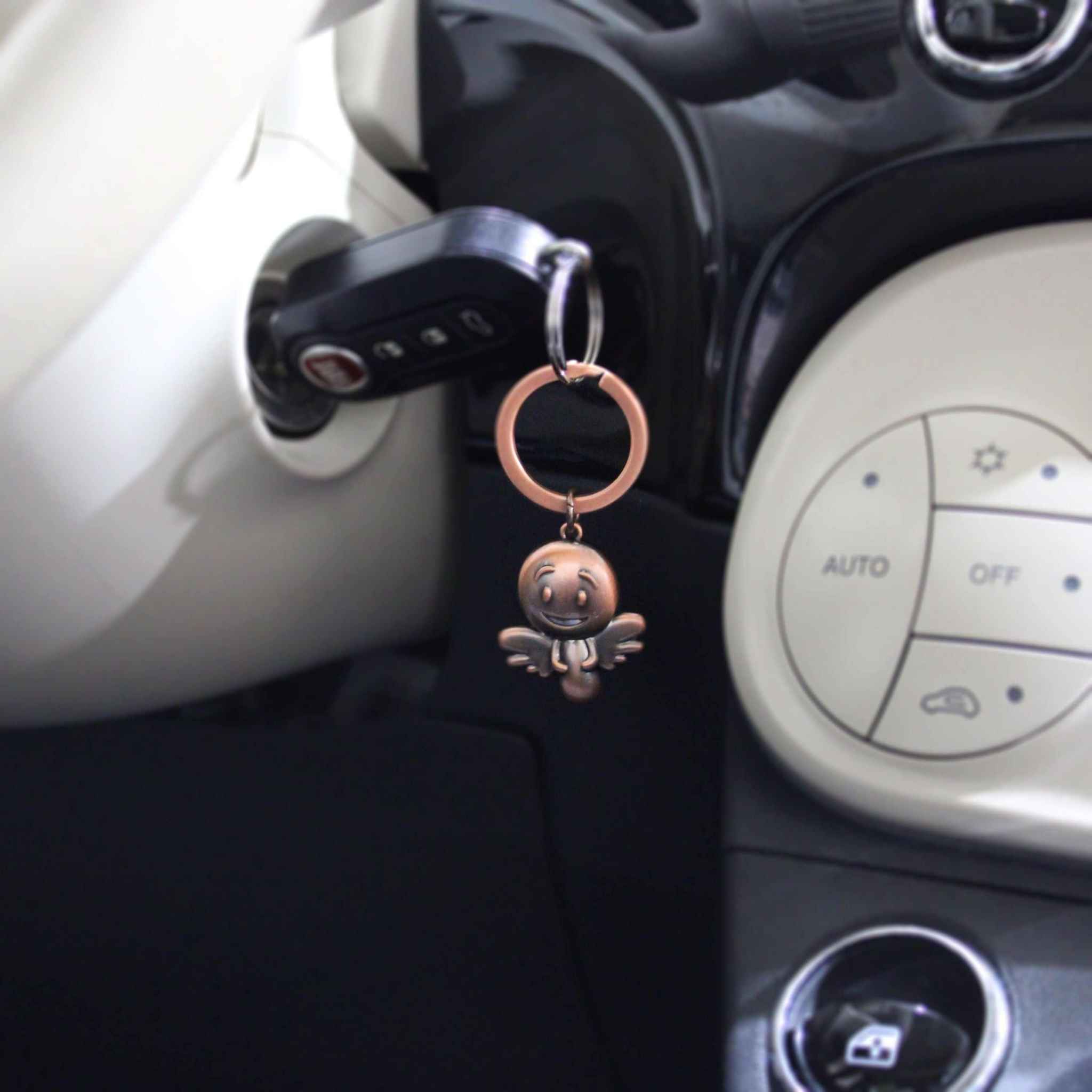 Schutzengel Schlüsselanhänger Engel Smiley in bronze vintage style attached to car keys in ignition.